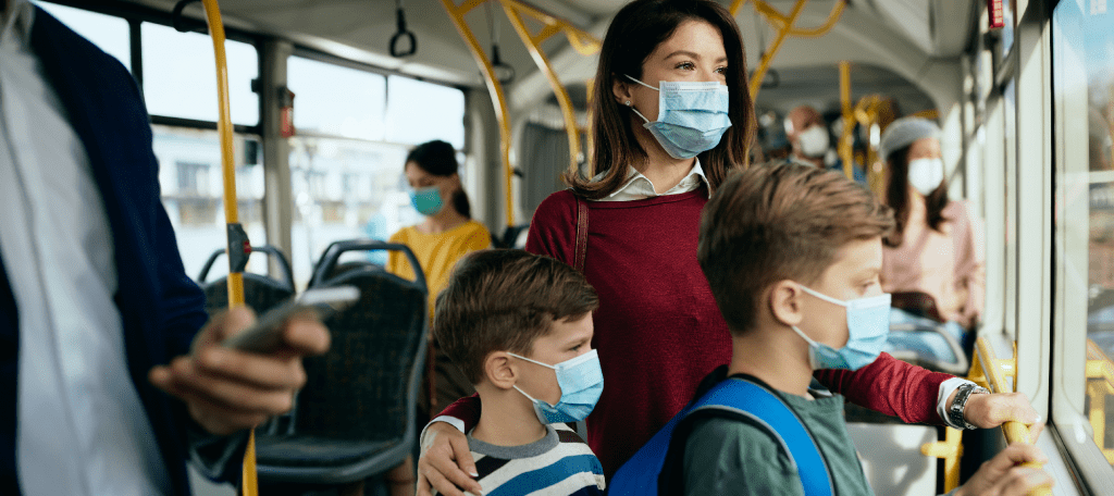 Woman and her two sons wearing mask on public bus
