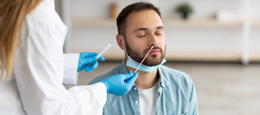 Man getting tested for covid using as nasal swab