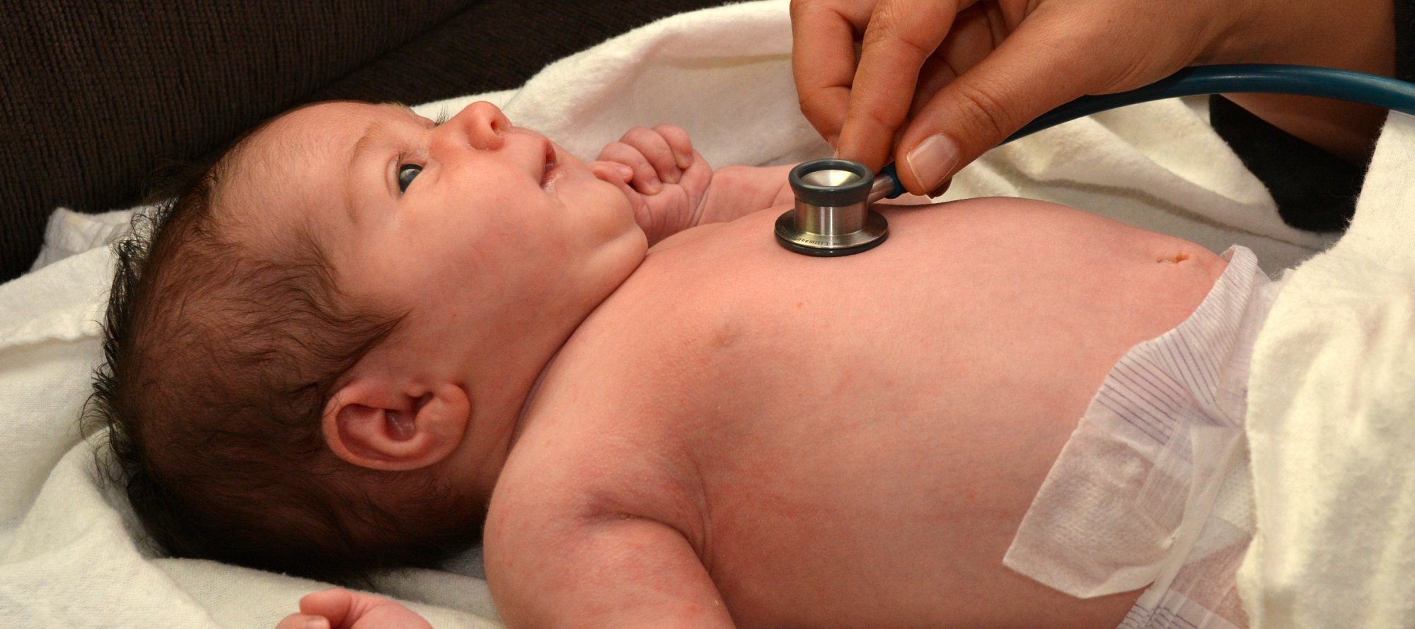 Doctor checking baby's heart