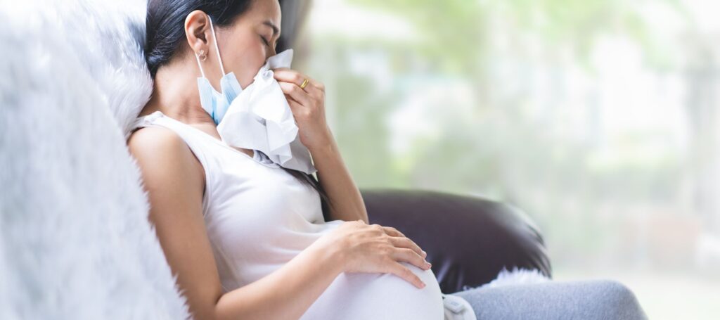 Asian pregnant woman unwell with the symptom of fever, runny nose and sneezing of viral infection and allergy, concept of sickness and healthcare in pregnancy in the situation of covid 19 outbreak