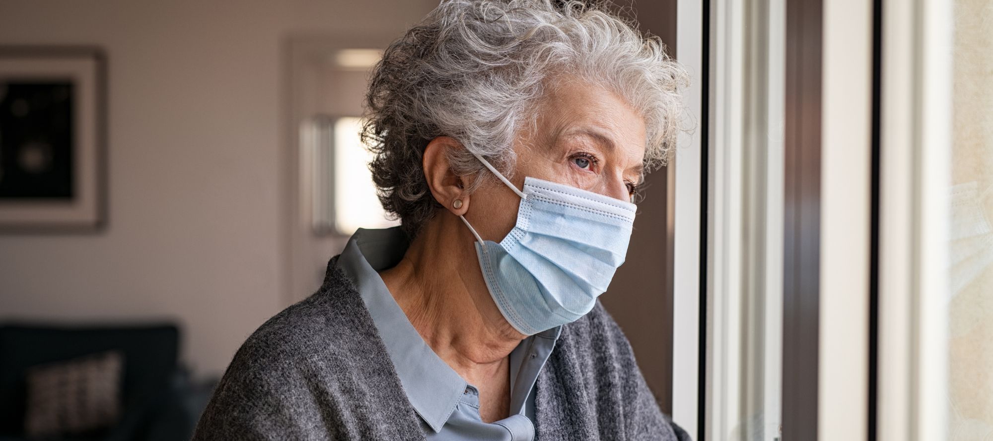Senior woman wearing face mask staying at home