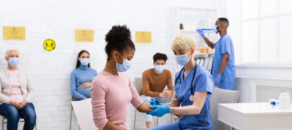Nurse giving COVID-19 vaccine injection to a patient