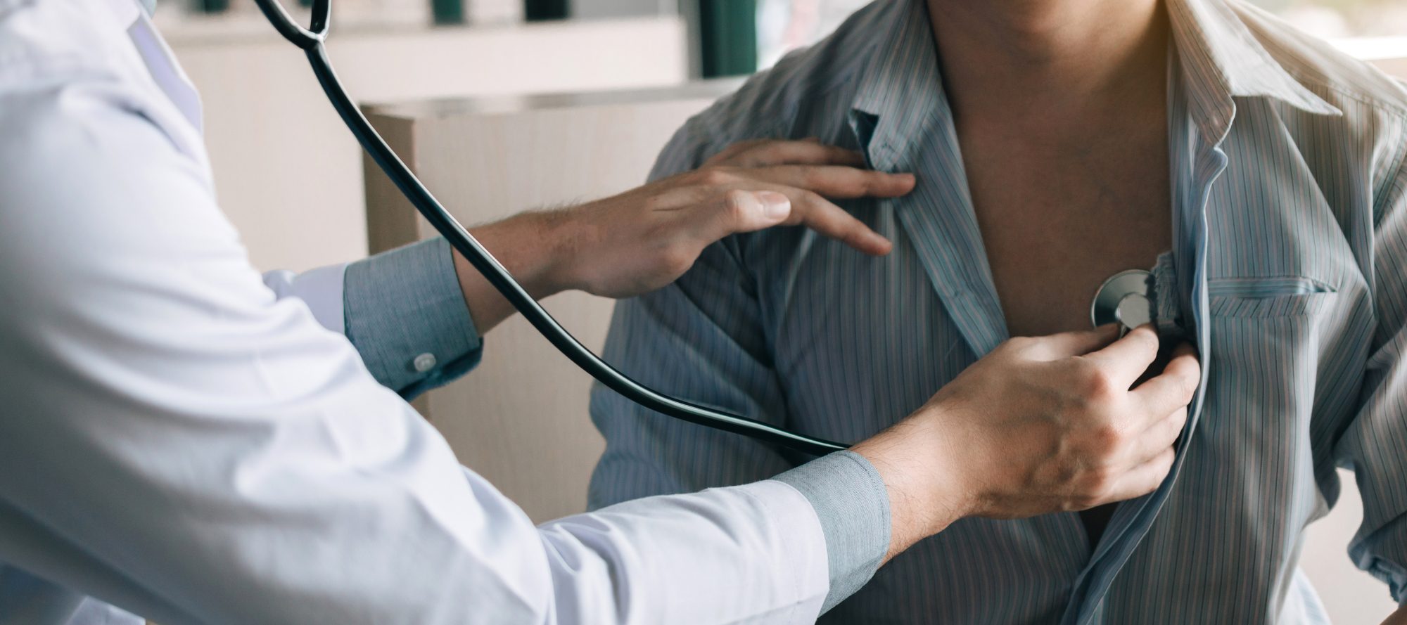 Doctor placing stethoscope on person's chest